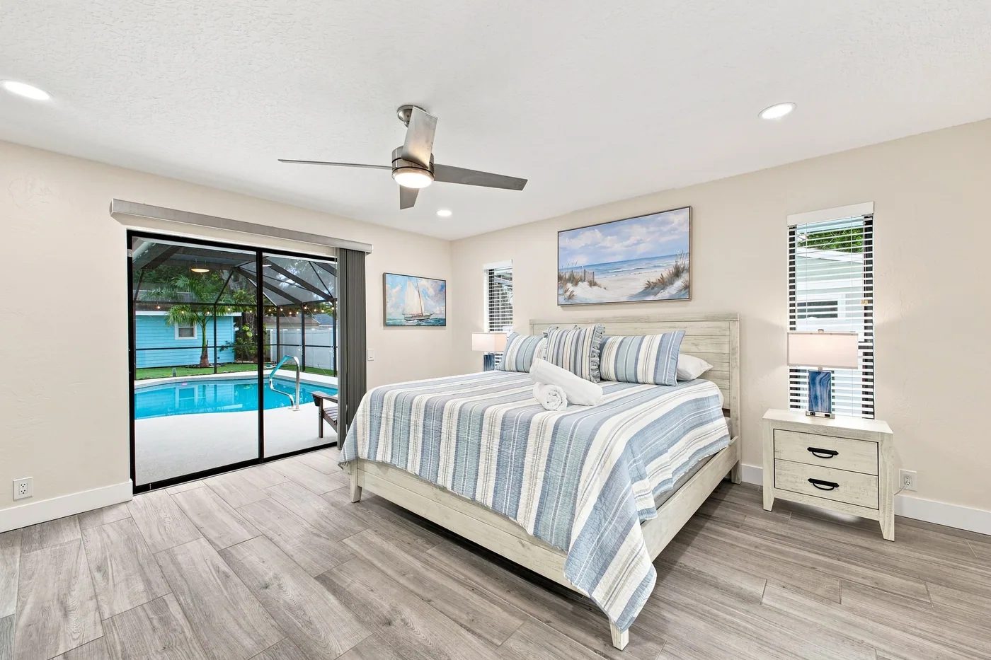Pickleball Pool Home Retreat — Primary bedroom with doors beside the screened pool