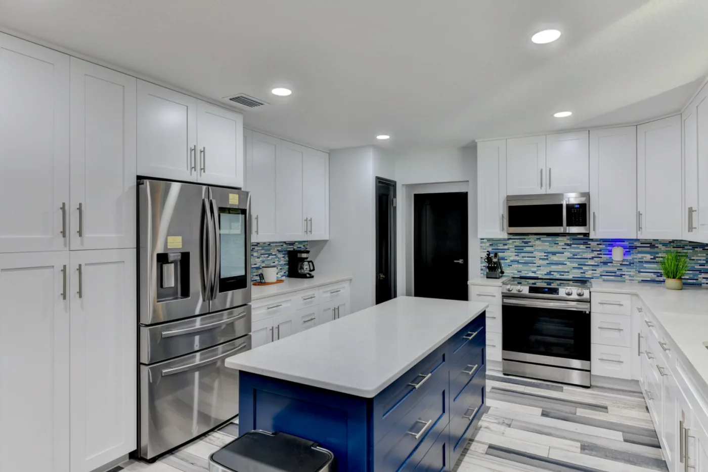 River House — Kitchen with a blue island and stainless appliances