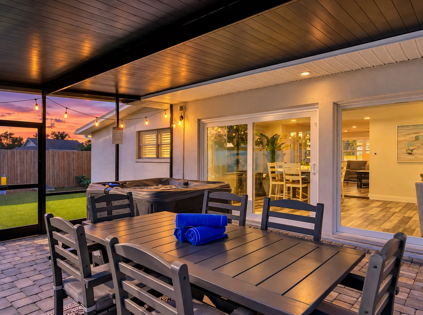 River House — Screened lanai dining table and spa at dusk